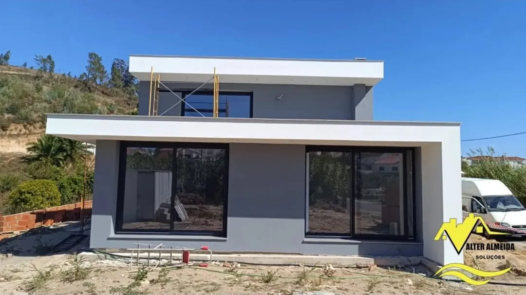 Moradia contemporânea com fachada pintada em branco e cinza